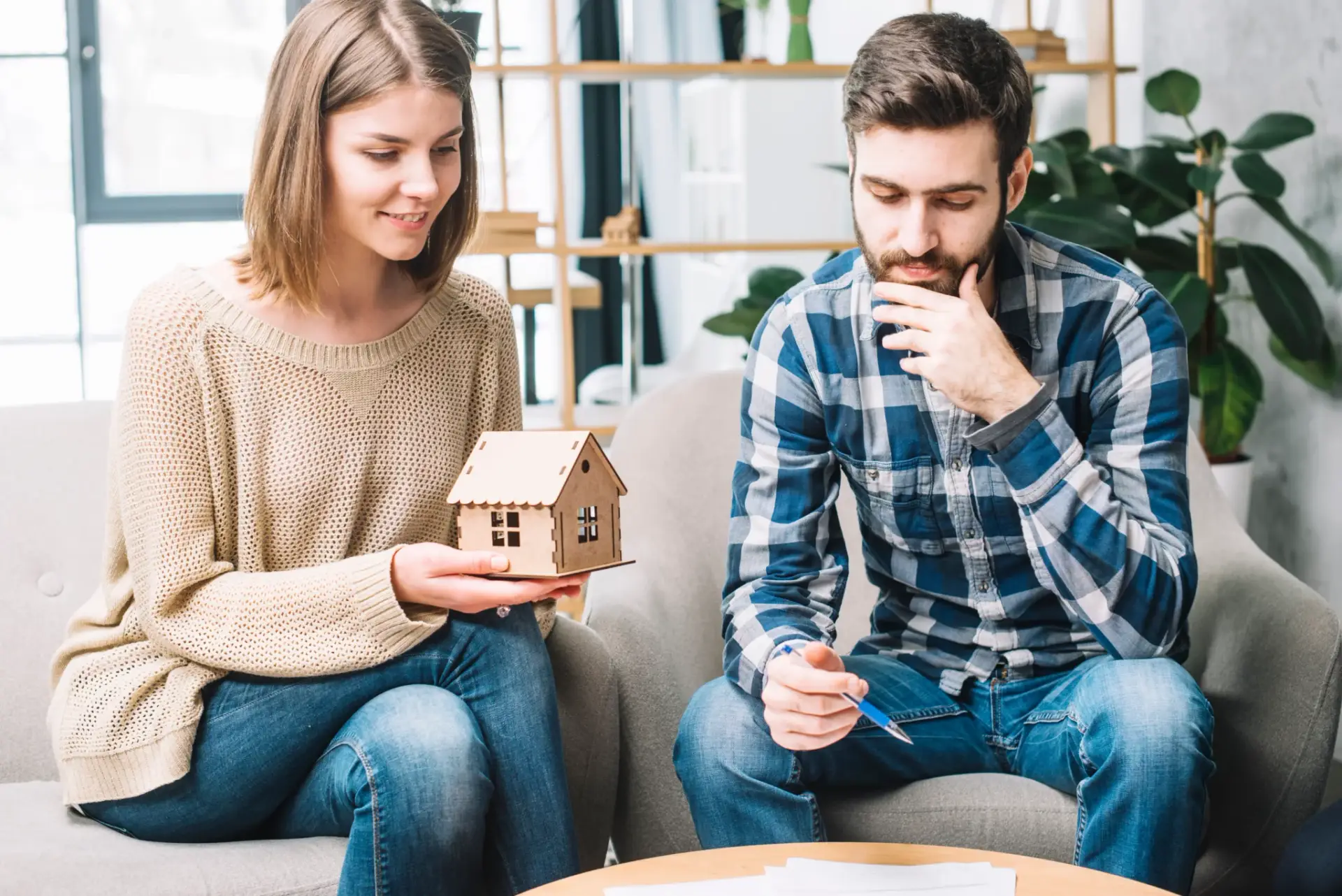Couple discussing home loan options for nurses with model house